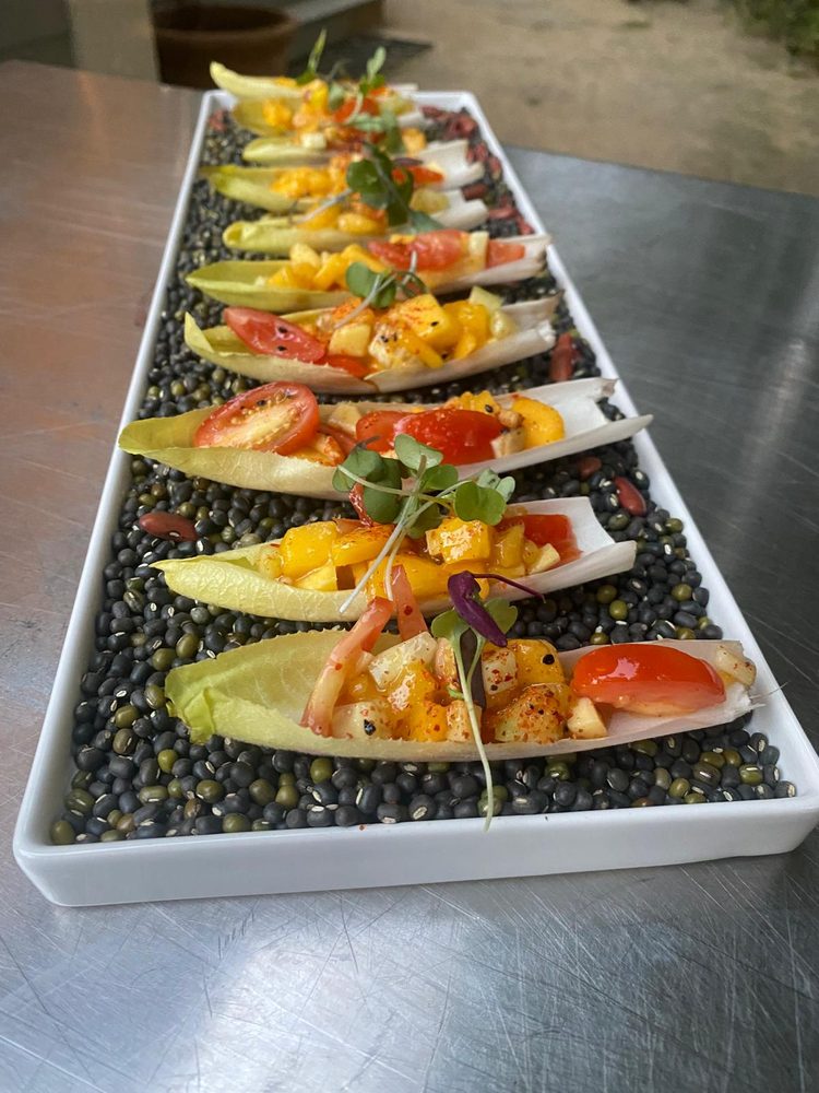 Endive leaves filled with mango and tomato salsa, plated over lentils