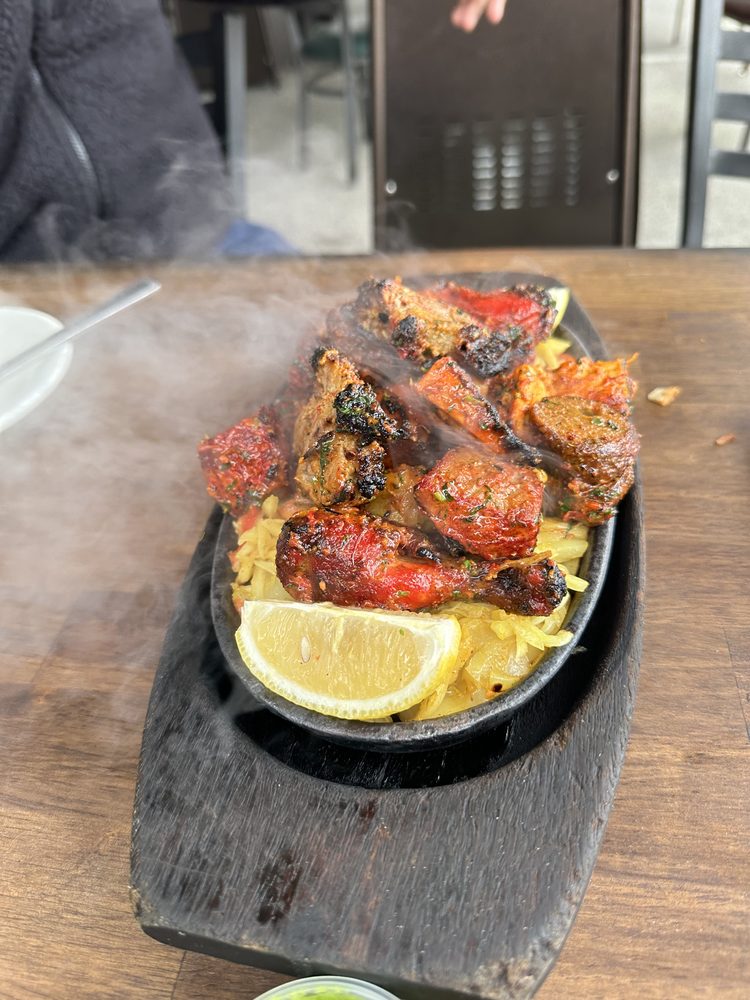 Grilled tandoori meat served in a steel catering dish